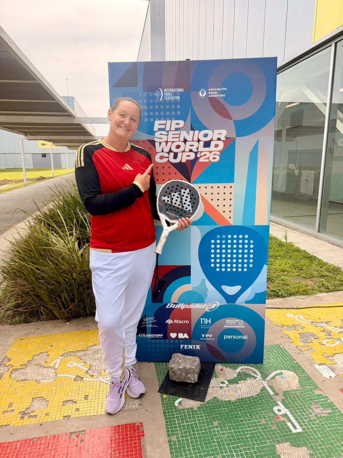 TCO-Trainerin Maren Tiedjen beim FIP Senior World Cup 2026 in Buenos Aires. Sie steht mit Padelschläger im deutschen Nationaltrikot vor dem offiziellen Turnieraufsteller.